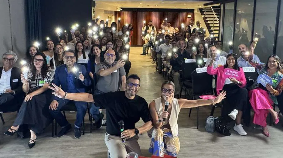 Lelia Orbegoso y Juanjo Dongo frente a un grupo de participantes con las manos en alto